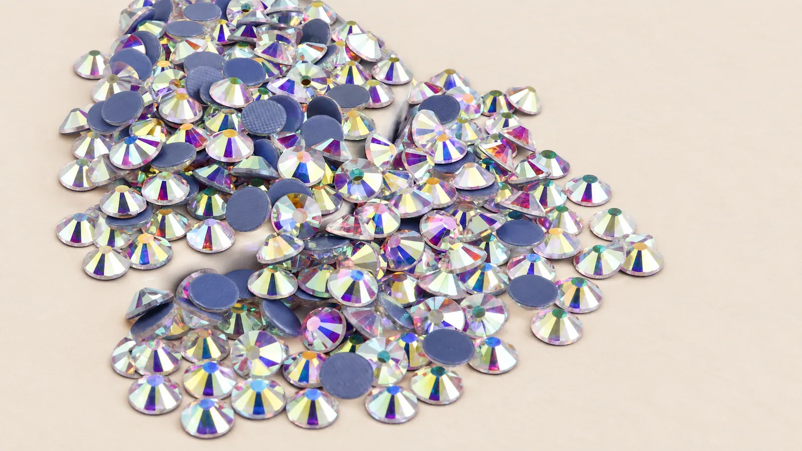AB Hotfix Rhinestones. Round iridescent stones showing faceted fronts and blue-gray flat backs. Source-based AI-edited visualization.